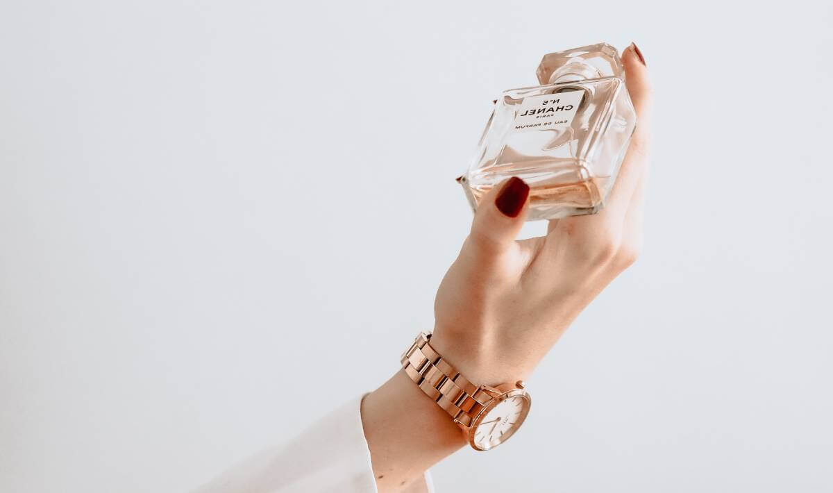 Ręka trzymająca damskie perfumy